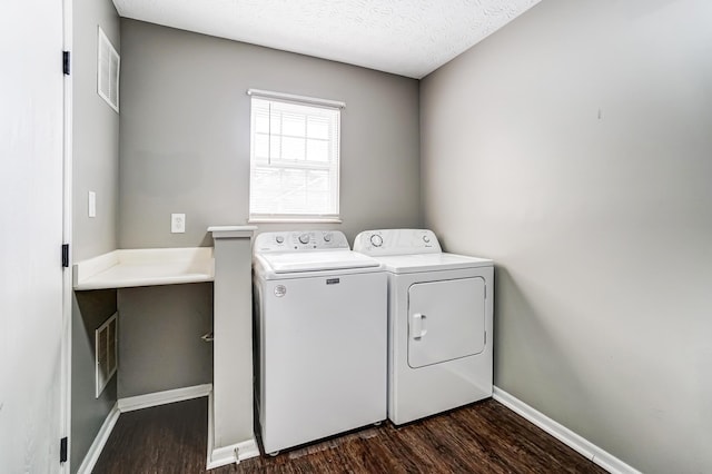 laundry room featuring laundry area, washing machine and dryer, dark wood finished floors, and baseboards