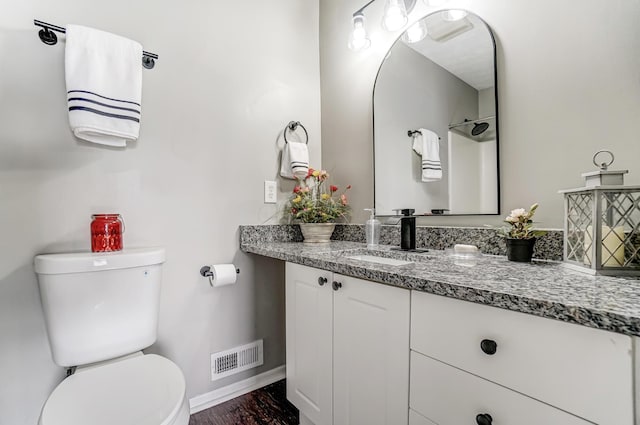 bathroom featuring baseboards, visible vents, vanity, and toilet