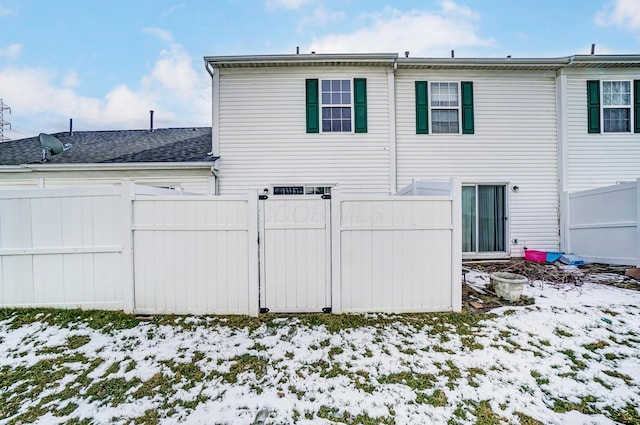 snow covered property with fence