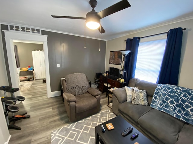 living room featuring ceiling fan, ornamental molding, and wood finished floors