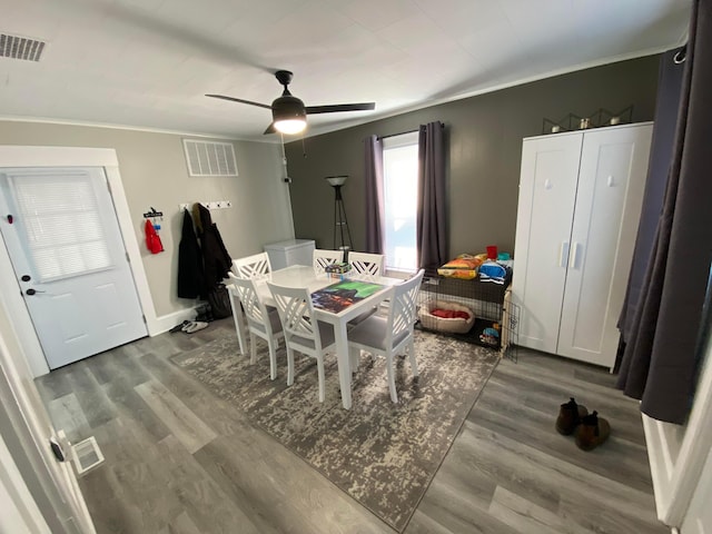 dining area with ceiling fan, visible vents, and wood finished floors