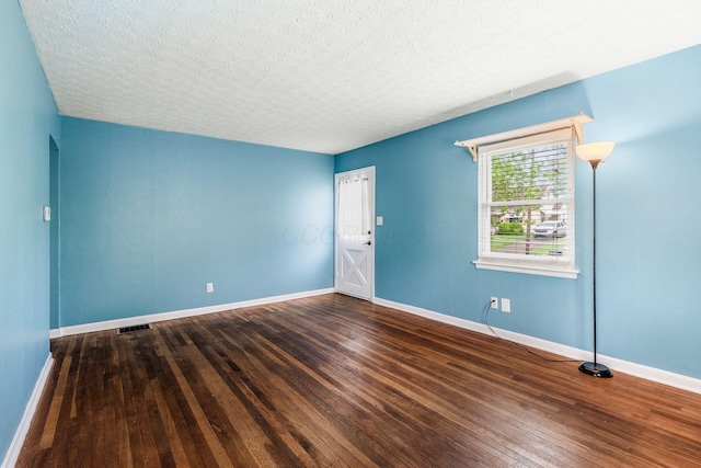 3093 Hamilton Ave, Columbus, OH 43224 - spare room featuring visible vents, a textured ceiling, baseboards, and hardwood / wood-style floors