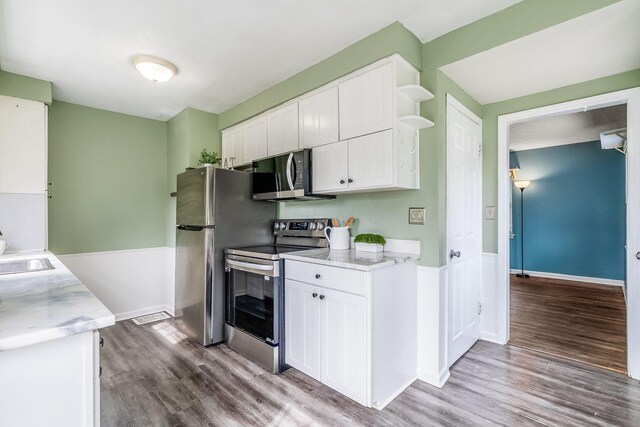 3093 Hamilton Ave, Columbus, OH 43224 - kitchen with open shelves, appliances with stainless steel finishes, wainscoting, white cabinetry, and wood finished floors