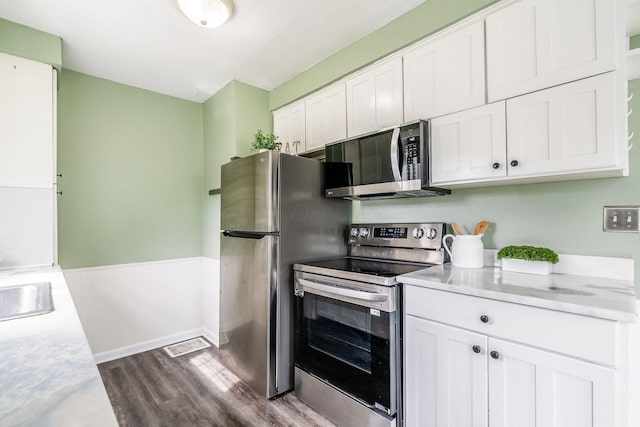 3093 Hamilton Ave, Columbus, OH 43224 - kitchen with light countertops, stainless steel appliances, dark wood-style flooring, and white cabinetry