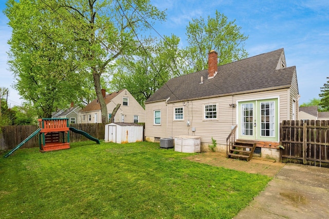 3093 Hamilton Ave, Columbus, OH 43224 - rear view of property with french doors, a storage shed, entry steps, a fenced backyard, and a playground