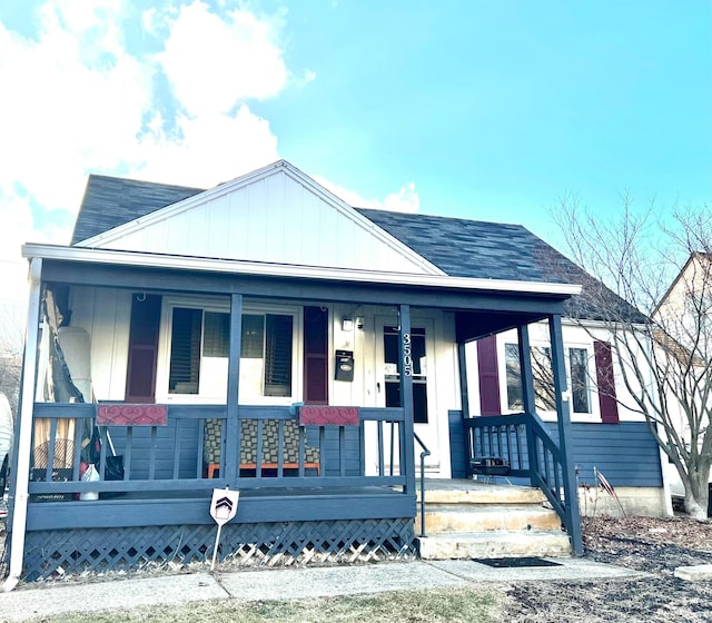 bungalow featuring a porch, board and batten siding, and roof with shingles