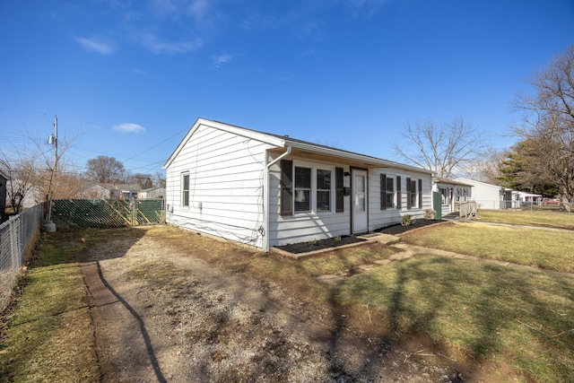 exterior space featuring driveway, fence, and a front yard