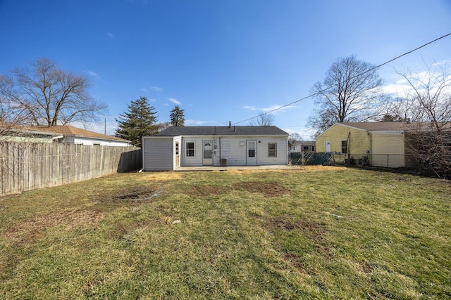 rear view of property with a lawn and a fenced backyard