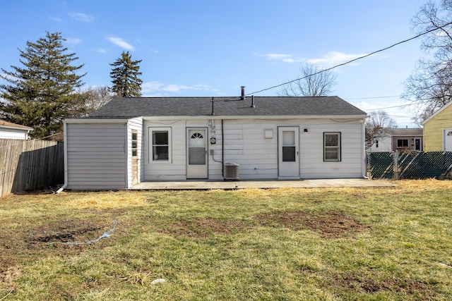 view of front of property featuring a patio area, a fenced backyard, a front lawn, and central AC unit