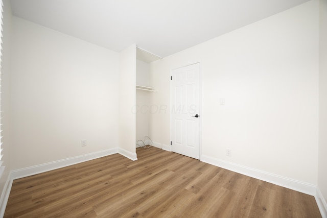 empty room with baseboards and wood finished floors