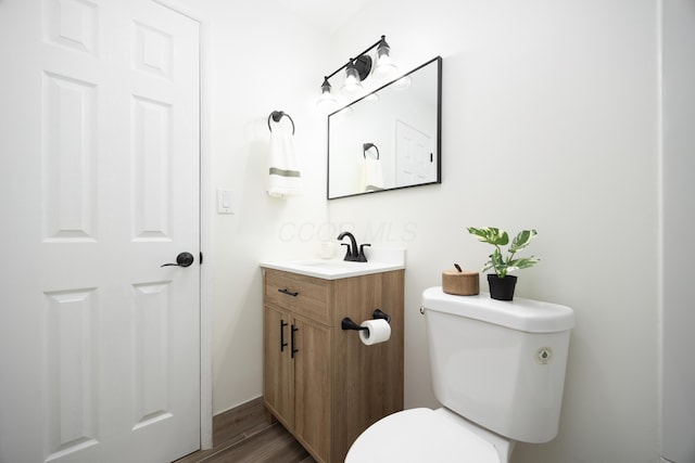 bathroom featuring vanity, toilet, and wood finished floors