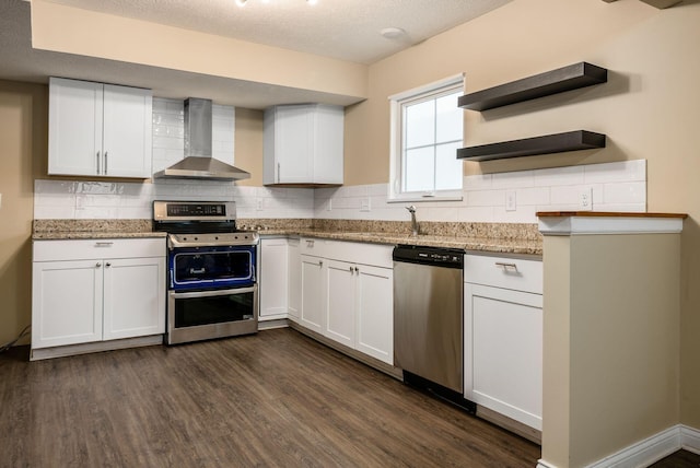 kitchen with wall chimney exhaust hood, appliances with stainless steel finishes, dark wood-style flooring, white cabinetry, and open shelves