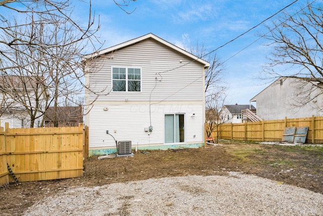 rear view of property featuring central air condition unit and fence