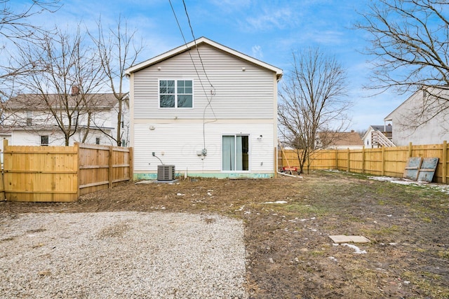 back of property featuring a fenced backyard and central AC