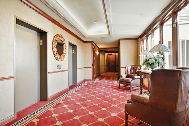 corridor with elevator, baseboards, and crown molding