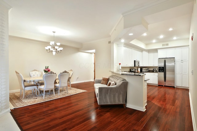 living area featuring crown molding, dark wood-type flooring, baseboards, and a notable chandelier