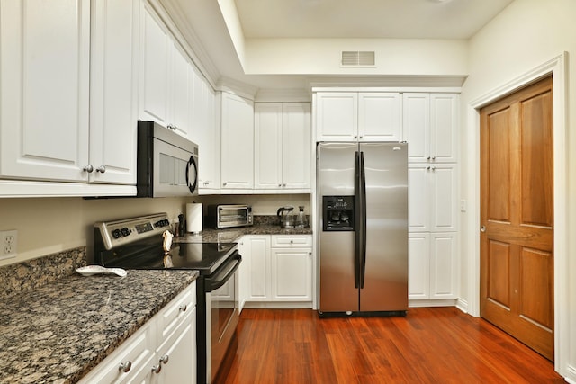 kitchen with a toaster, dark wood finished floors, visible vents, appliances with stainless steel finishes, and white cabinetry