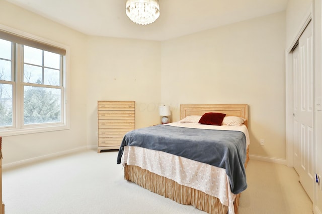 carpeted bedroom featuring a closet and baseboards