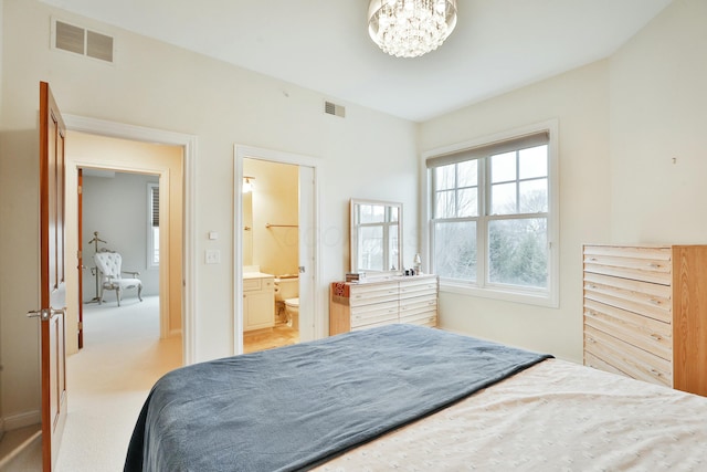 bedroom with light carpet, an inviting chandelier, visible vents, and connected bathroom