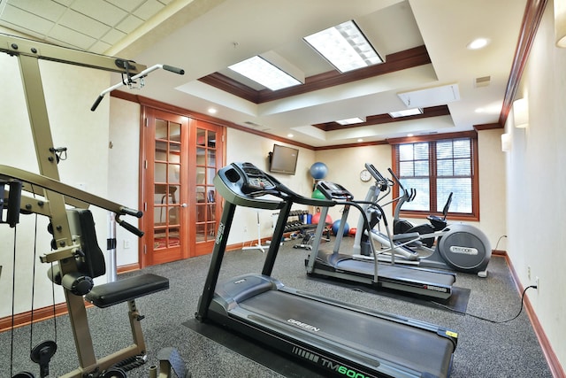 exercise room with baseboards, ornamental molding, a raised ceiling, and french doors