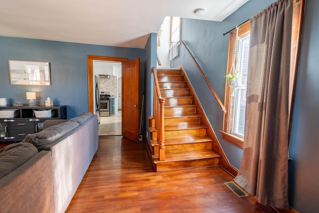 staircase featuring wood finished floors and visible vents