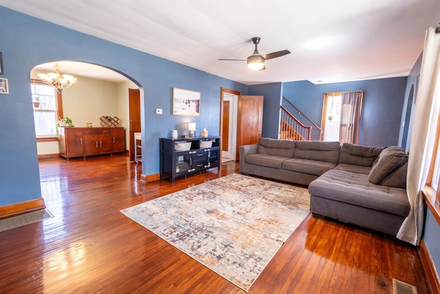 living room featuring arched walkways, visible vents, plenty of natural light, and wood finished floors