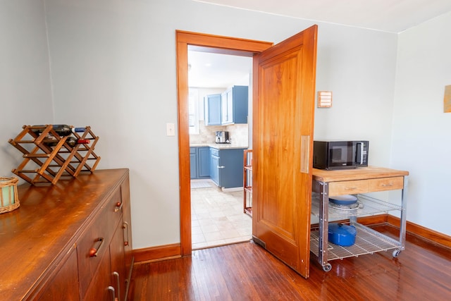 interior space featuring wood-type flooring and baseboards