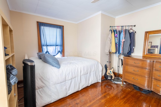 bedroom with baseboards, ornamental molding, and wood finished floors