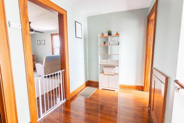 hall featuring baseboards and wood finished floors