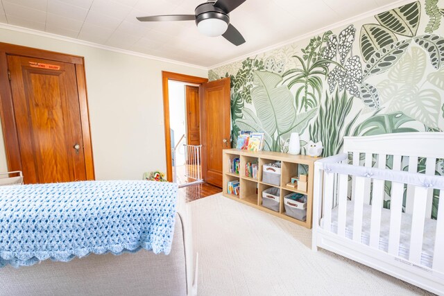 bedroom with ceiling fan, wood finished floors, and crown molding