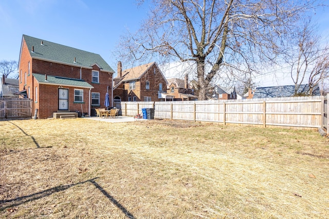 view of yard featuring entry steps, a fenced backyard, and a patio