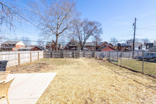 view of yard featuring a fenced backyard and a residential view