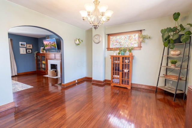 interior space featuring a brick fireplace, baseboards, and wood finished floors