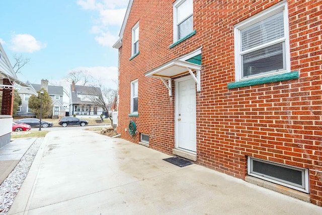 view of exterior entry with a residential view and brick siding