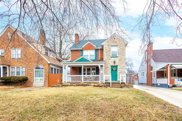 view of front of home with stone siding, a chimney, covered porch, a front lawn, and brick siding