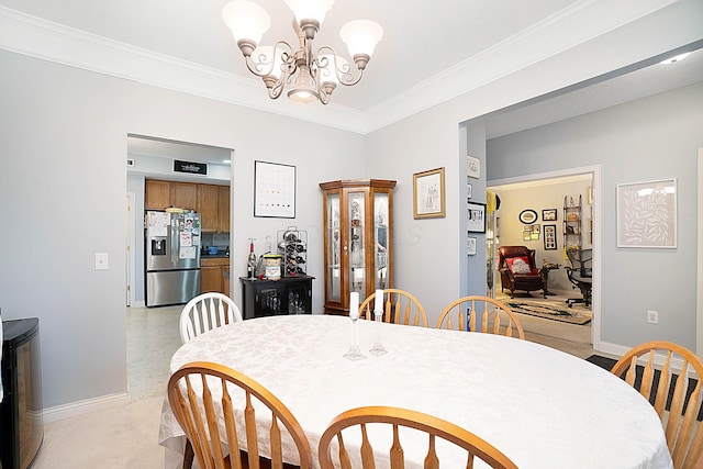 dining area featuring crown molding, baseboards, and an inviting chandelier