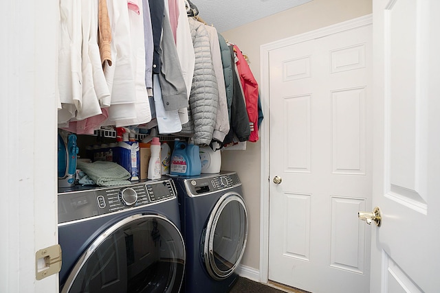 clothes washing area with a textured ceiling, laundry area, and washing machine and clothes dryer