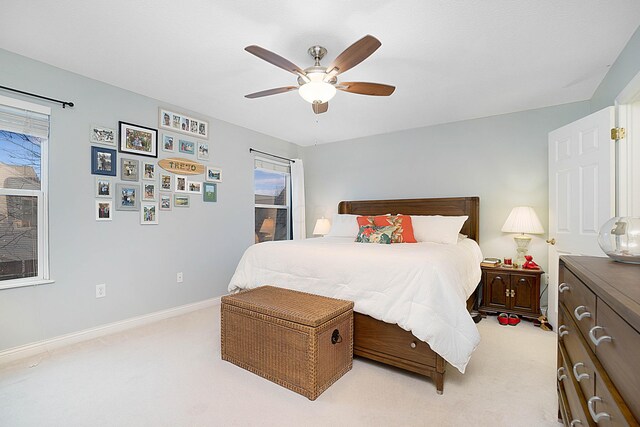 bedroom with light carpet, ceiling fan, and baseboards