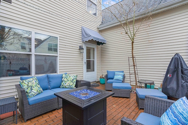 view of patio with an outdoor living space with a fire pit