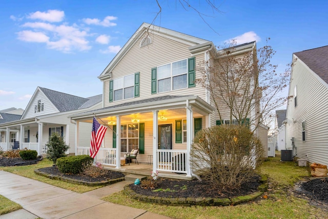 traditional-style house featuring central AC unit and a porch