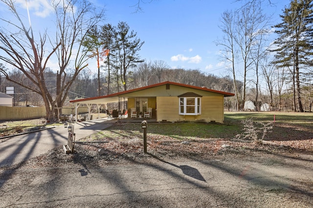 view of front of house with driveway, an attached carport, and a front yard