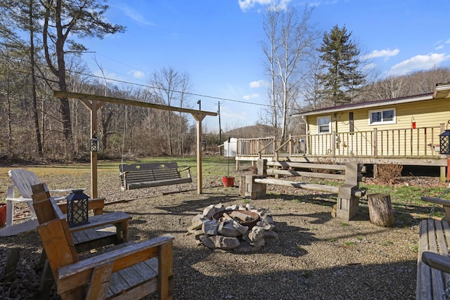 view of yard featuring a fire pit and a wooden deck