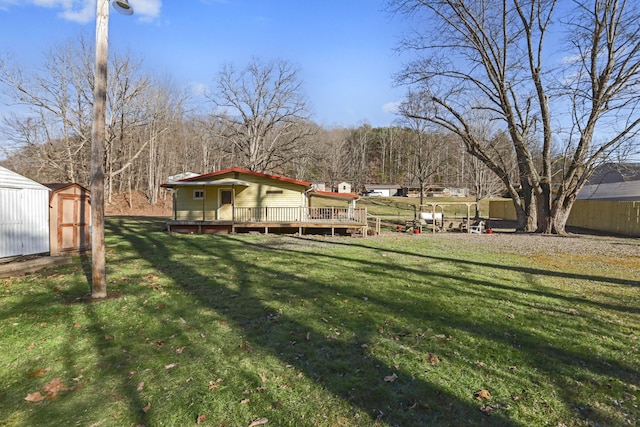 view of yard with a storage shed, a wooden deck, and an outdoor structure