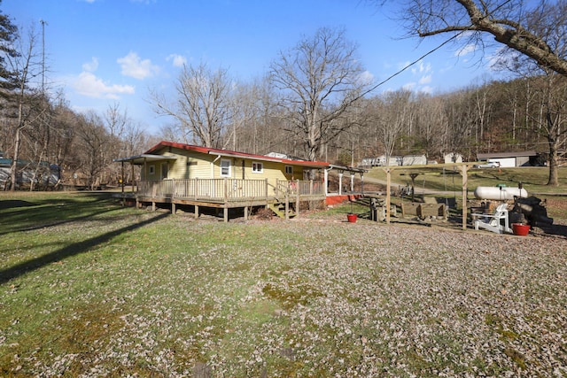 rear view of house with a yard and a deck