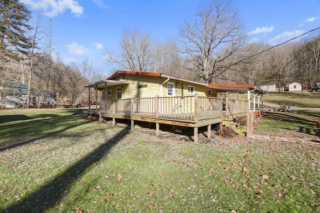 rear view of house featuring a deck and a lawn