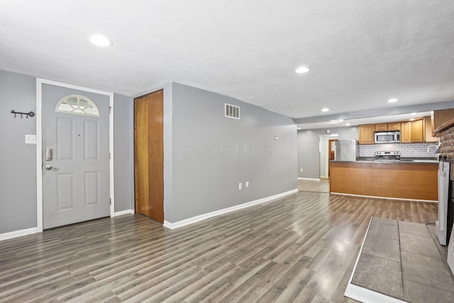 foyer entrance with recessed lighting, visible vents, baseboards, and wood finished floors