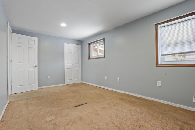 unfurnished bedroom with carpet, baseboards, visible vents, and a closet