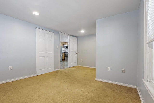 interior space featuring recessed lighting, baseboards, a closet, and light colored carpet