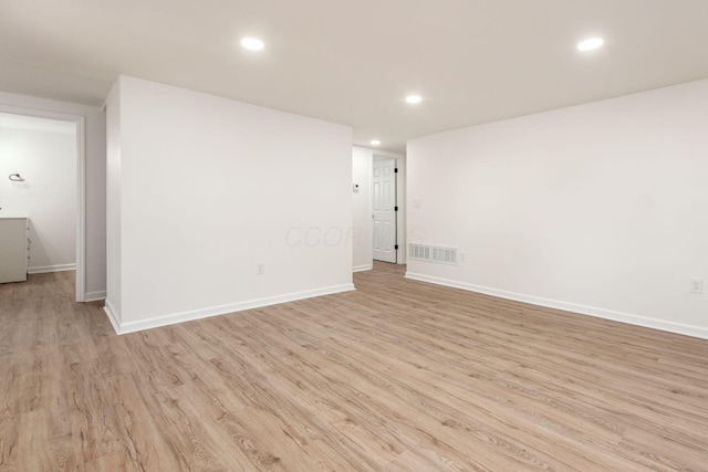 unfurnished room featuring baseboards, light wood-type flooring, visible vents, and recessed lighting