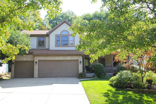 view of front facade with roof with shingles, a garage, stone siding, driveway, and a front lawn